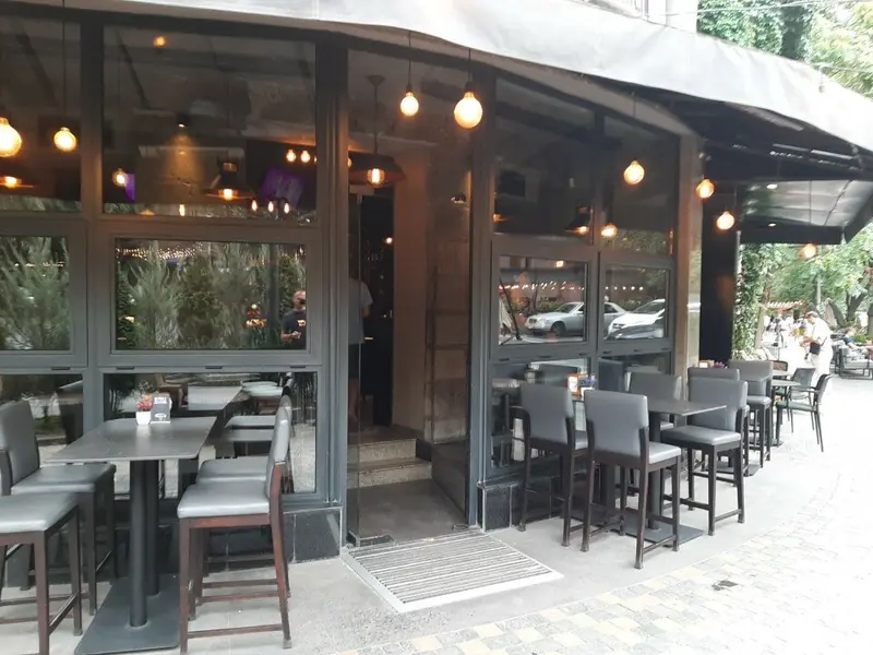 The glass front with hanging bulbs and high tables by the door